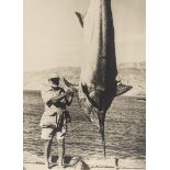 Hemingway (Ernest).- Photograph of Hemingway with a Marlin, [1950s].