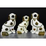 A pair of Staffordshire white glazed and copper lustre chimney spaniels, together with another