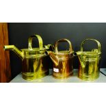 A group of two brass watering cans and another in copper, largest 27cm high,(3)