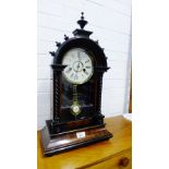 A mahogany cased clock, the arched top with urn finials over an enamel dial with Roman numerals