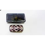 A Present from the Isle of Man a black lacquered papier mache snuff box and a brass and ruby glass