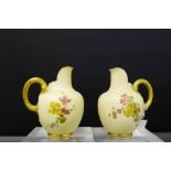 A pair of Royal Worcester blush ivory floral patterned jugs with gilt loop handles to side, shape