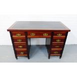 A mahogany kneehole desk, the rectangular top with inset leather skiver over an arrangement of