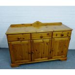 A pine ledgeback sideboard, fitted three drawers and three cupboard doors to the base 92 x 135cm