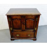 An oak cabinet, the rectangular top over two panelled doors and a single drawer to the base, with