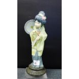 A Lladro porcelain figure of a Japanese girl, modelled standing with her parasol resting on her