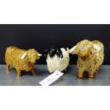 Two stoneware highland cow figures together with a black faced ram, (3)