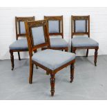 A set of four oak side chairs with foliate carved top rails, upholstered backs and seats, raised