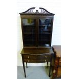 A mahogany display cabinet, the swan neck over a Chippendale style carved frieze and pair of