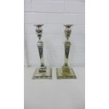 A pair of Epns candlesticks of square tapering form with floral garland embossed decoration, on