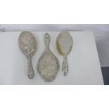 A Walker & Hall silver backed hand mirror and matching clothes brush together with a similar