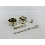 A mixed lot to include silver pocket postal scale, two silver napkin rings, silver button hook and a