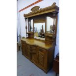 An oak mirror back dresser with bow front drawers and carved panelled doors to the base, 190 x 255cm