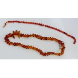 A strand of amber beads together with a strand of polished amber coloured beads (2)