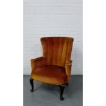 An upholstered armchair on mahogany cabriole supports