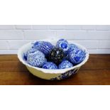 A Staffordshire blue and white bowl containing sixteen blue and white ceramic carpet bowls and a