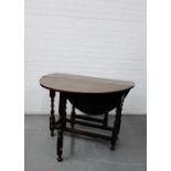 An oak drop leaf table with a single drawer raised on turned supports, 73 x 98cm