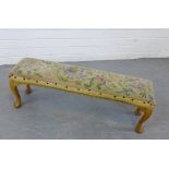 A long footstool with tapestry upholstered top and cabriole legs