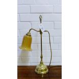 A brass lamp with frilled rim glass shade
