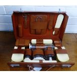 A leather cased travelling set containing a quantity of glass, chrome and ivory backed accessories