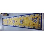 A Chinese silk runner with Dragon and cloud pattern within blue borders, 335 x 70cm