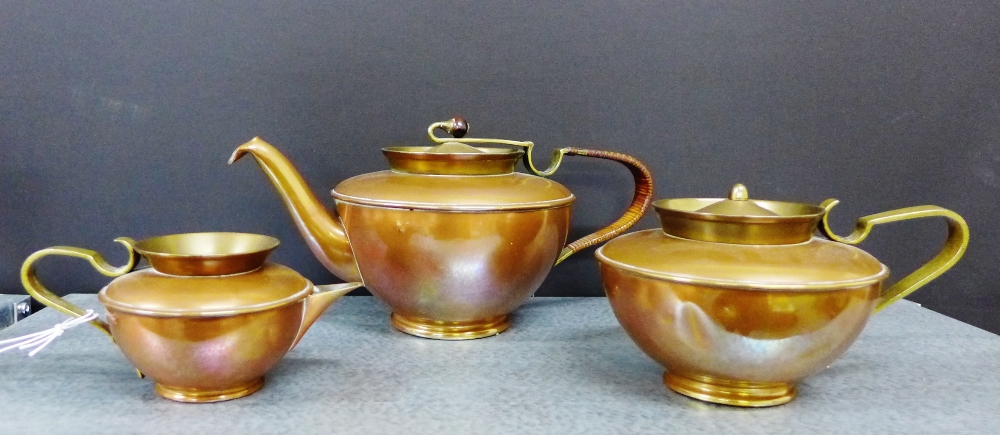 A WMF copper and brass three piece tea set comprising teapot with a raffia bound handle, milk jug