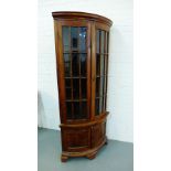 A stained hardwood floor standing corner cabinet, with glazed doors above two panelled doors, 200