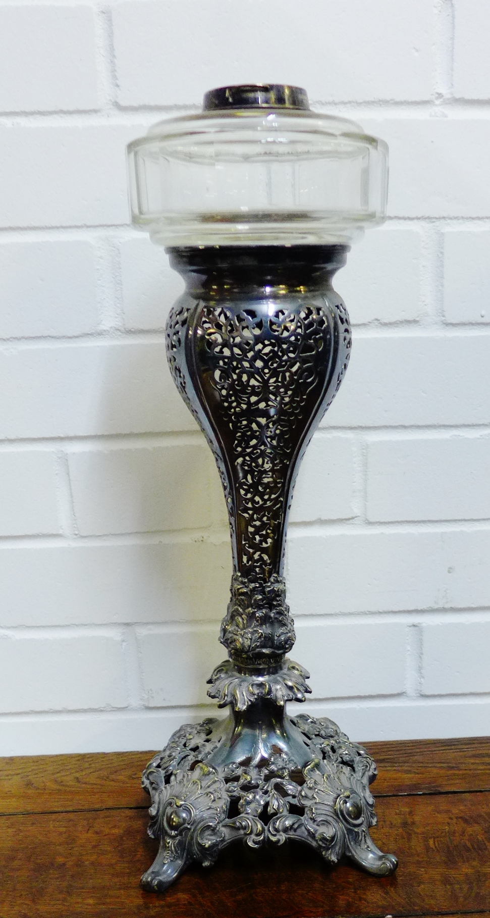 An Epns oil lamp base with a clear glass well, 47cm high