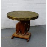 An Eastern side table with a circular brass engraved top on a carved elephant hardwood base, 52 x