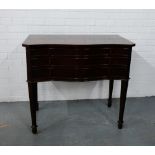 A mahogany serpentine fronted side table, the rectangular top over three long drawers on reeded