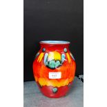 A Poole pottery red glazed baluster vase with orange, blue and green splash decoration, 20cm high