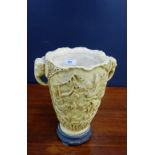 A faux ivory resin vase with elephant head handles to side