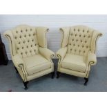 A pair of cream upholstered button back wing armchairs on cabriole supports, 106 x 94cm