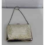 A George V silver purse with foliate engraved decoration, opening to reveal a soft grey leather