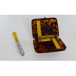 A white metal mounted and amber cheroot holder together with a tortoiseshell cigarette case (2)