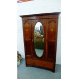 A mahogany and inlaid wardrobe, the cornice top above a central mirror panelled door flanked by