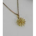 A 15 carat gold star shaped and seed pearl brooch with a pendant suspension lop, hanging on a yellow