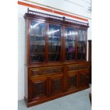 A Victorian mahogany bookcase cabinet, the dentil cornice with a galleried top, over four glazed