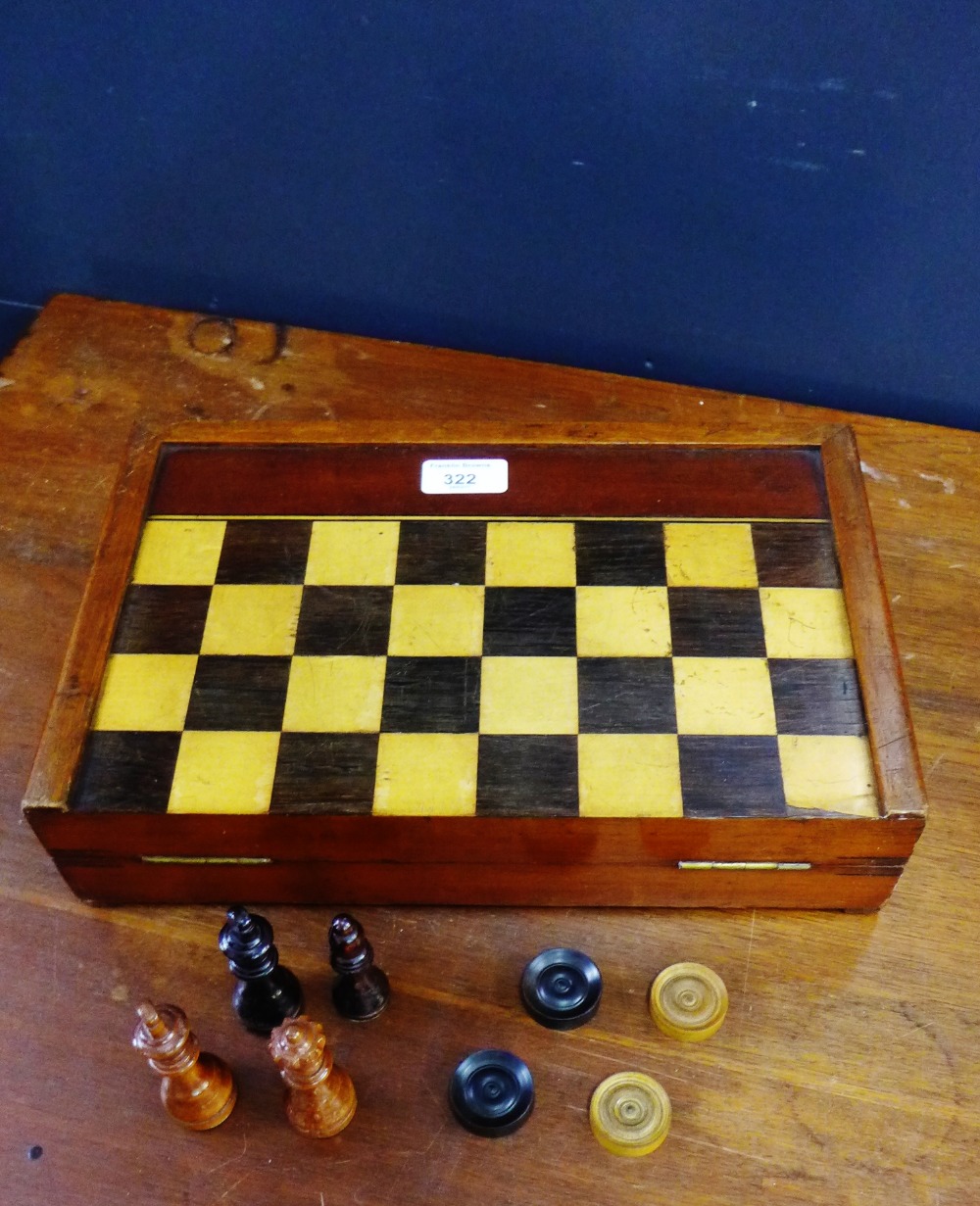 A folding mahogany backgammon and chess board, containing a set of chess pieces and a draught set