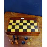 A folding mahogany backgammon and chess board, containing a set of chess pieces and a draught set