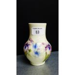 A Moorcroft white glazed vase with irises pattern with impressed and printed back stamps, 13cm high