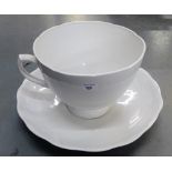 A large white glazed teacup and saucer, 27cm high (2)