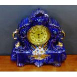 A blue glazed ceramic mantle clock painted with floral sprays and gilt highlights, 45cm high