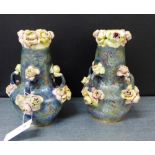 A pair of Austrian Amphora vases, each with four handles and rose bud encrusted rims with a lustre