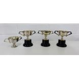 Four Sheffield silver twin handled trophy cups, three on ebonised stands, all bearing Viners