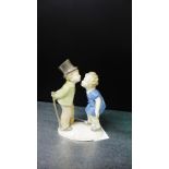 A Lladro style porcelain figure of a kissing boy and girl