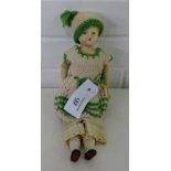 A bisque head doll with cloth body and bisque limbs, having moulded curly hair and blue eyes,