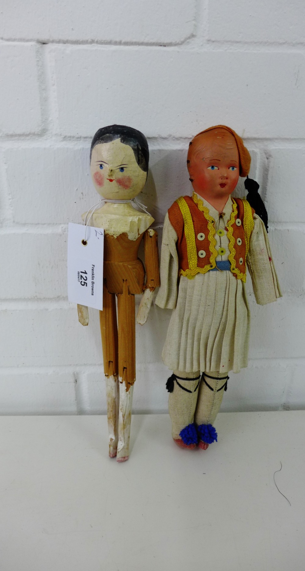 A vintage painted wooden head and body doll, 28cm long together with a vintage costume doll 29cm