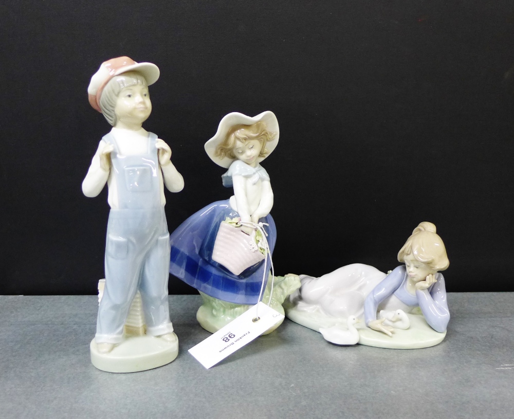 Three Lladro porcelain figures to include a girl and ducks, a boy in dungarees and a girl with a