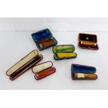A collection of amber cheroot holders to include two 9 carat gold mounted examples, three silver